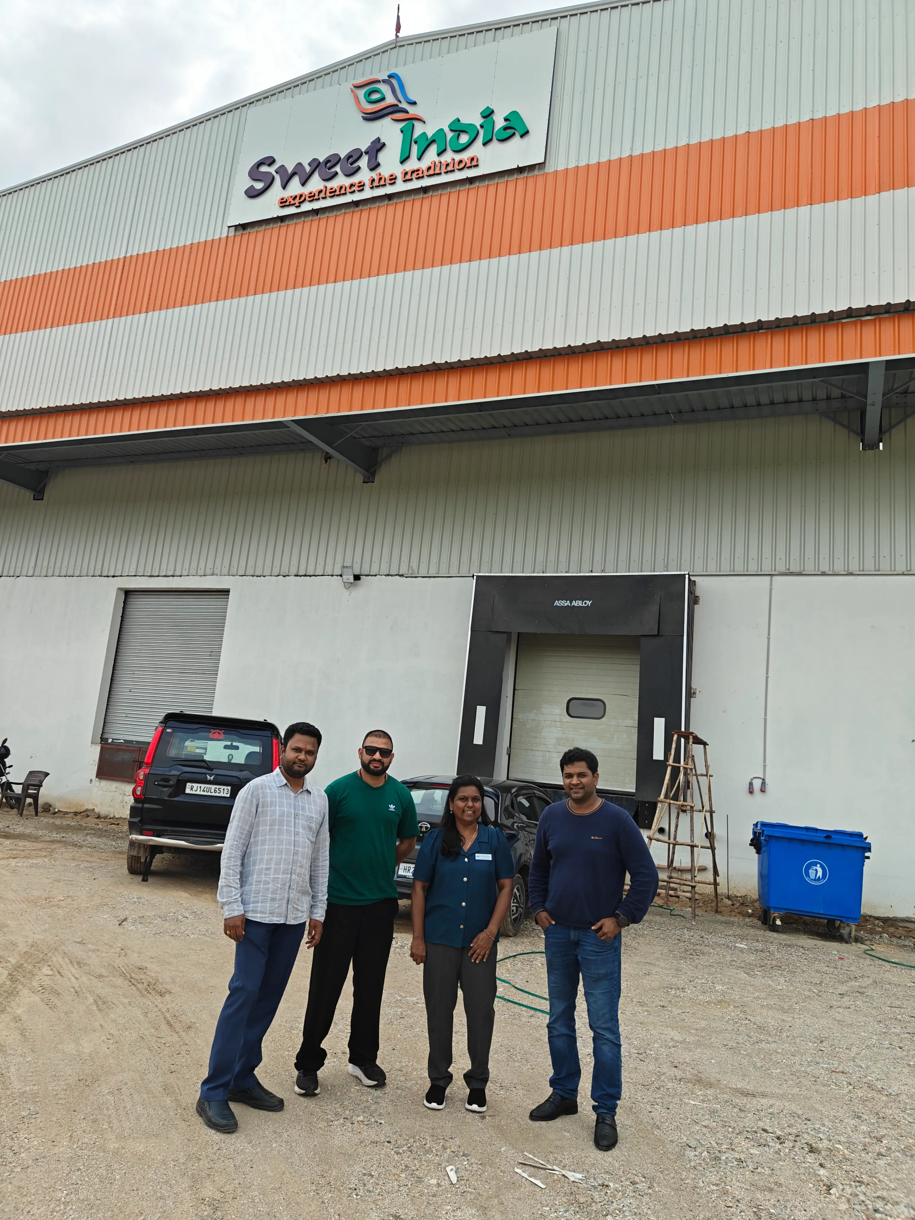 Four professionals standing outside a food manufacturing unit during a facility visit.